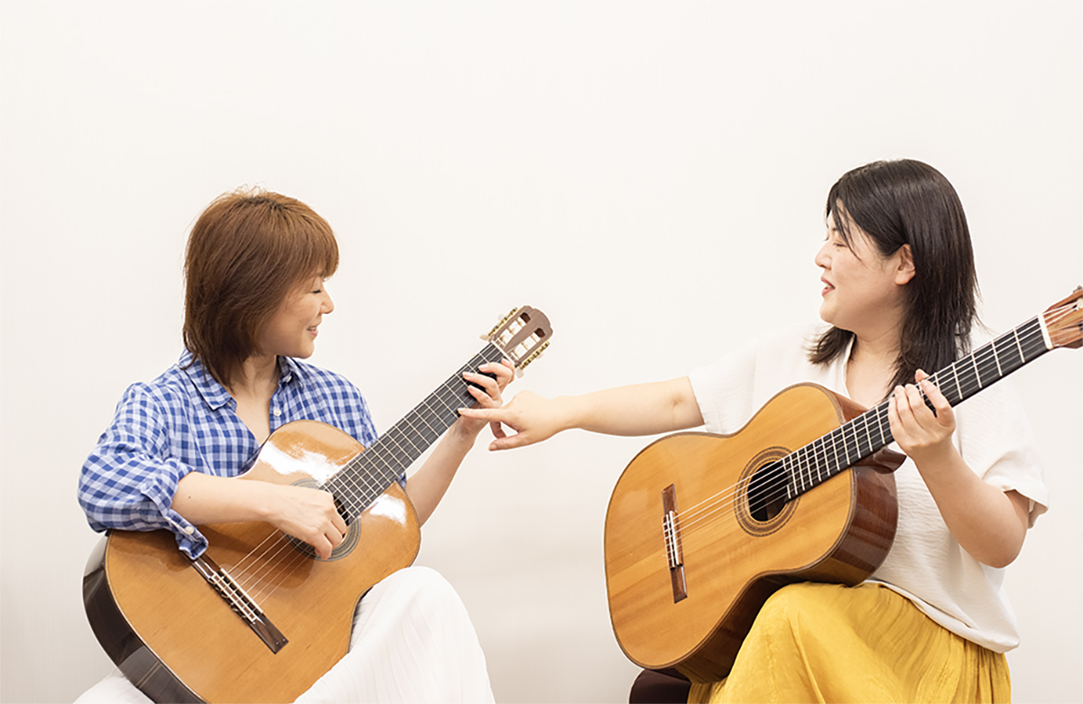 女性がギターレッスンを受ける様子
